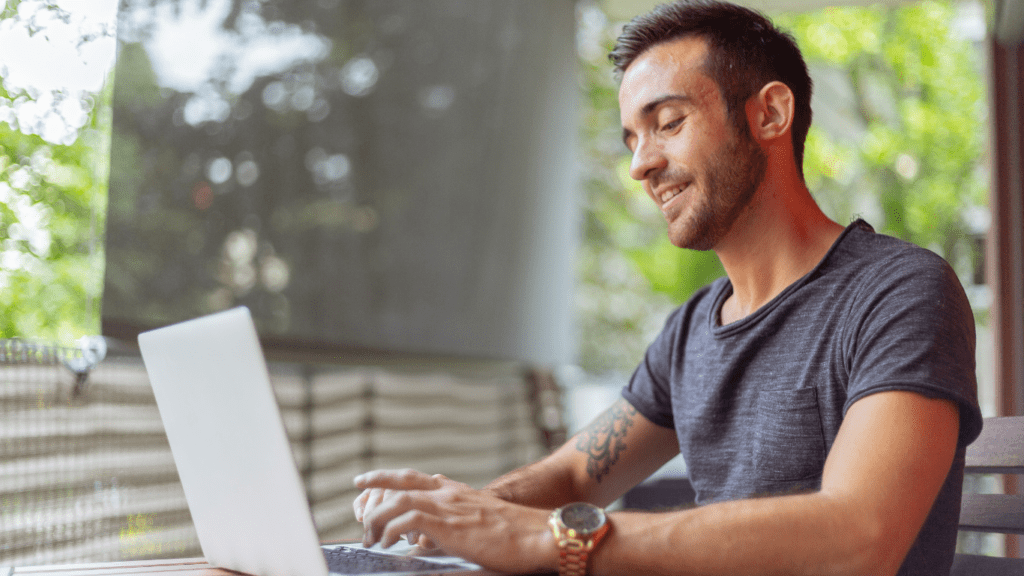 Smiling person working on laptop