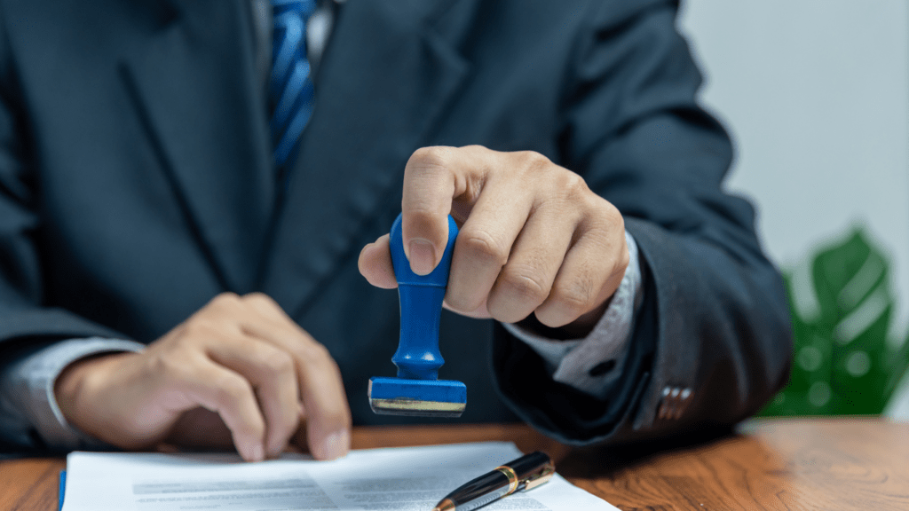 a person in a suit holding a rubber stamp on a piece of paper