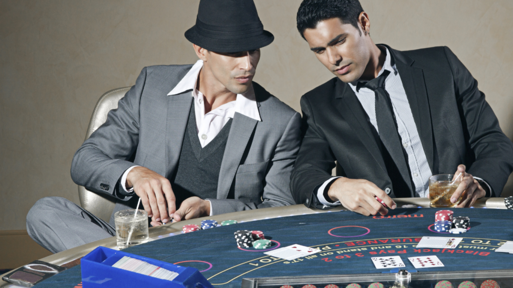 Two people playing blackjack at a casino table