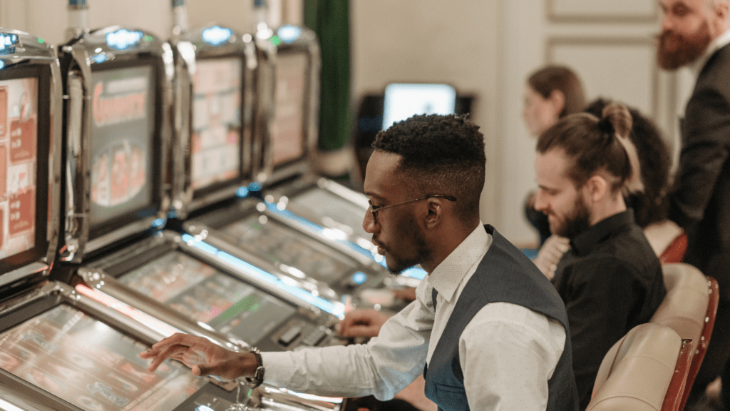 a group of people playing slot machines at a casino