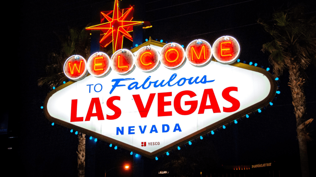 a welcome sign for Las Vegas in front of palm trees