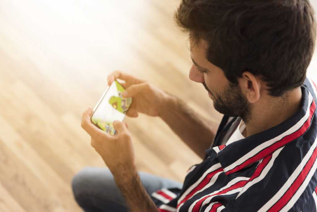 top view man playing mobile games